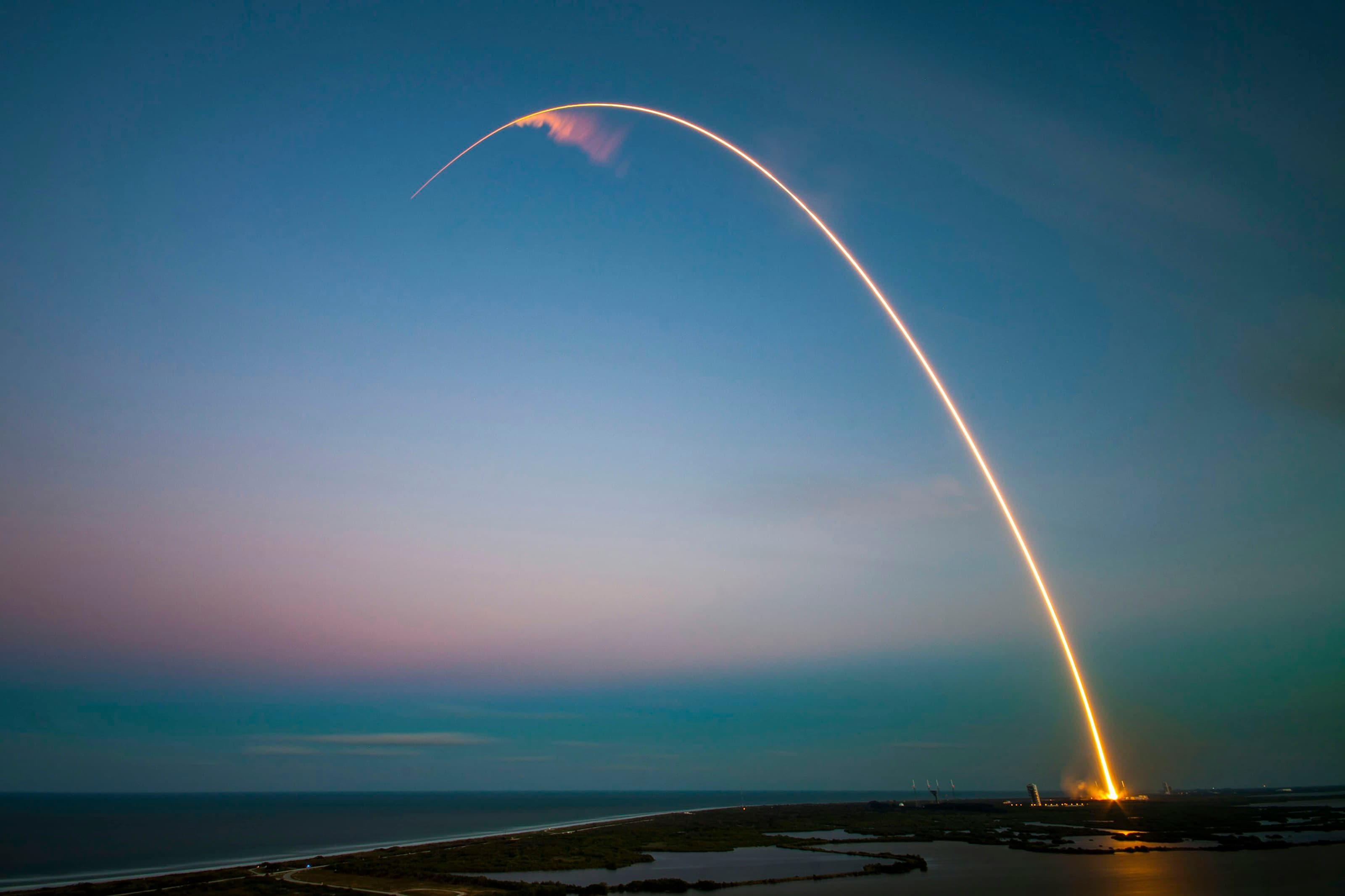 A rocket climbing over Florida’s Space Coast at dusk
